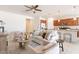 Comfortable living room with a ceiling fan, neutral-toned furniture, and an open floor plan connected to the kitchen at 17532 W Copper Ridge Dr, Goodyear, AZ 85338