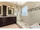 Bathroom featuring glass enclosed shower with seat, dual sink vanity and tile floors at 18171 W Marshall Ln, Surprise, AZ 85388