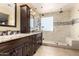 Bathroom featuring a glass-enclosed shower with seat, dual sink vanity, and tile floors at 18171 W Marshall Ln, Surprise, AZ 85388