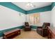 Bedroom with cozy armchairs, white walls, and a pop of color on the walls at 18171 W Marshall Ln, Surprise, AZ 85388