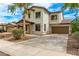 Lovely two-story home featuring stone accents and a lush front yard with mature trees at 18171 W Marshall Ln, Surprise, AZ 85388