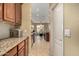 Galley kitchen with granite countertops, tile backsplash, and wood cabinets, open to dining area at 18171 W Marshall Ln, Surprise, AZ 85388
