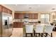 Modern kitchen with stainless steel appliances, granite countertops, and a breakfast bar with seating at 18171 W Marshall Ln, Surprise, AZ 85388