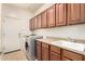 Functional laundry room with a sink, washer, dryer, storage cabinets, and counter space at 18171 W Marshall Ln, Surprise, AZ 85388