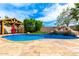 Beautiful pool featuring a waterfall, a built-in grotto, and a covered outdoor grilling area at 18171 W Marshall Ln, Surprise, AZ 85388