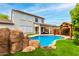 Stunning backyard with a rock feature by the pool, gazebo and covered patio with comfortable outdoor seating at 18171 W Marshall Ln, Surprise, AZ 85388