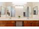 Bathroom featuring dual sinks, large mirrors, and vanity lighting at 1821 N 74Th Pl, Mesa, AZ 85207