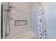 Bathroom featuring white subway tile, shower niche, and a patterned curtain covering a bathtub at 19029 E Mary Ann Way, Queen Creek, AZ 85142