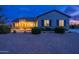 Charming single-story home featuring a covered porch with outdoor seating, desert landscaping, and warm exterior lighting at 19029 E Mary Ann Way, Queen Creek, AZ 85142