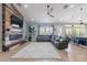 Open concept living room with fireplace, flatscreen TV, large sectional sofa, and wood look tile flooring at 19029 E Mary Ann Way, Queen Creek, AZ 85142