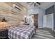 This stylish main bedroom features a barn door entry to the bath and decorative wood accent wall at 19029 E Mary Ann Way, Queen Creek, AZ 85142