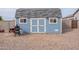 Charming blue shed in the backyard with double doors and window features at 19029 E Mary Ann Way, Queen Creek, AZ 85142