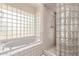 Bright bathroom features a bathtub, glass block shower, and white tile at 1954 N Calle Maderas --, Mesa, AZ 85213
