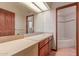 Bathroom featuring double sinks, a full-width mirror, tiled floors and a separate tub with tiled shower at 1954 N Calle Maderas --, Mesa, AZ 85213