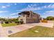 Beautiful home exterior showing a large yard, mature landscaping, and an attached three car garage at 1954 N Calle Maderas --, Mesa, AZ 85213