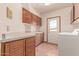 Bright laundry room features wood cabinets, white countertops, terracotta flooring, and an exterior door at 1954 N Calle Maderas --, Mesa, AZ 85213