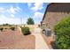 View of backyard with pavers leading to a gate and view of the grassy yard with an American flag at 20426 N Blazing Sun Rd, Maricopa, AZ 85138
