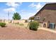 Side view of a well-kept backyard with grass, bushes, and an American flag in the distance at 20426 N Blazing Sun Rd, Maricopa, AZ 85138