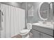 Well-lit bathroom featuring neutral gray color palette, white shower curtain, and oval mirror at 20426 N Blazing Sun Rd, Maricopa, AZ 85138