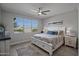 Comfortable bedroom featuring large windows, a ceiling fan, and a cozy bed with neutral décor at 20426 N Blazing Sun Rd, Maricopa, AZ 85138