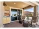 Cozy covered patio with comfortable seating, outdoor views, and a sliding glass door entrance at 20426 N Blazing Sun Rd, Maricopa, AZ 85138