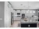 A modern kitchen features an island with a stainless steel sink, white cabinets, and stainless steel appliances at 20426 N Blazing Sun Rd, Maricopa, AZ 85138