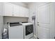 Efficient laundry room with white cabinets and modern washer and dryer units at 20426 N Blazing Sun Rd, Maricopa, AZ 85138