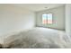 A bright, spacious bedroom features an expansive window, bare concrete floors, and a neutral color palette at 22709 E Saddle Way, Queen Creek, AZ 85142