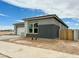 Well-lit exterior showcases the modern gray stucco, landscaped yard and the side gate of this single-Gathering home at 22709 E Saddle Way, Queen Creek, AZ 85142