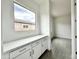 Hallway with stylish white cabinets, quartz countertops, modern fixtures, and a large window offering exterior views at 22709 E Saddle Way, Queen Creek, AZ 85142