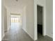 Bright hallway with light-colored flooring that leads to an open area and a bathroom at 22709 E Saddle Way, Queen Creek, AZ 85142