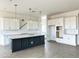 A kitchen displays white cabinetry, an island with dark navy panelling and quartz countertops, and stainless pendant lighting at 22709 E Saddle Way, Queen Creek, AZ 85142
