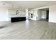 An open-concept kitchen features an island with dark navy panelling, quartz countertops, white cabinets, and stainless pendant lighting at 22709 E Saddle Way, Queen Creek, AZ 85142