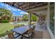 Inviting covered patio with dining and lounge areas overlooking the sparkling pool and landscaped backyard at 2496 E Lindrick Dr, Gilbert, AZ 85298