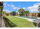 Beautiful backyard featuring a pool, grassy lawn, tasteful landscaping, and a fun trampoline at 2496 E Lindrick Dr, Gilbert, AZ 85298