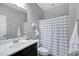 Well-maintained bathroom featuring a single sink vanity, shower with curtain, and towel for added comfort at 2496 E Lindrick Dr, Gilbert, AZ 85298