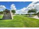 Scenic community view showcasing lush landscaping, a tranquil lake with fountains, and walking paths on a sunny day at 2496 E Lindrick Dr, Gilbert, AZ 85298