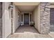 Inviting front porch with stone accents, decorative lights, and a cozy bench for a welcoming entrance at 2496 E Lindrick Dr, Gilbert, AZ 85298