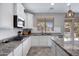 Bright kitchen features white cabinets, granite countertops, stainless appliances, and backyard views at 2496 E Lindrick Dr, Gilbert, AZ 85298