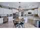Bright kitchen with white cabinetry, stainless appliances, and large center island with seating at 2496 E Lindrick Dr, Gilbert, AZ 85298