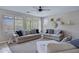 Comfortable living room with neutral tones, bright windows, and stylish ceiling fan at 2496 E Lindrick Dr, Gilbert, AZ 85298