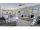 Bright living space with open layout to kitchen with ample seating, ceiling fan, and natural light at 2496 E Lindrick Dr, Gilbert, AZ 85298