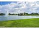 A picturesque pond with a fountain is framed by lush green grass and the building is off in the background at 2496 E Lindrick Dr, Gilbert, AZ 85298