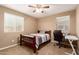Comfortable bedroom featuring two windows, a bed, a desk, and a chair at 2607 W Gray Wolf Trl, Phoenix, AZ 85085