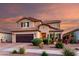 Stunning two-story home featuring desert landscaping, complemented by a brown garage door and shuttered windows at 2607 W Gray Wolf Trl, Phoenix, AZ 85085