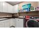 Well-equipped laundry room with white cabinetry and modern washer and dryer at 2607 W Gray Wolf Trl, Phoenix, AZ 85085