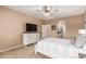 Bright main bedroom with carpet, television, ceiling fan, and access to the main bathroom at 2607 W Gray Wolf Trl, Phoenix, AZ 85085