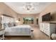 Spacious main bedroom featuring large windows, ceiling fan, television, and carpeted floors at 2607 W Gray Wolf Trl, Phoenix, AZ 85085