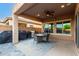 Spacious covered patio with ceiling fan, dining set, and an outdoor grill, perfect for entertaining guests at 2607 W Gray Wolf Trl, Phoenix, AZ 85085