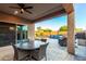 Inviting covered patio with ceiling fan, dining set, and view of the sparkling pool with waterfall feature at 2607 W Gray Wolf Trl, Phoenix, AZ 85085